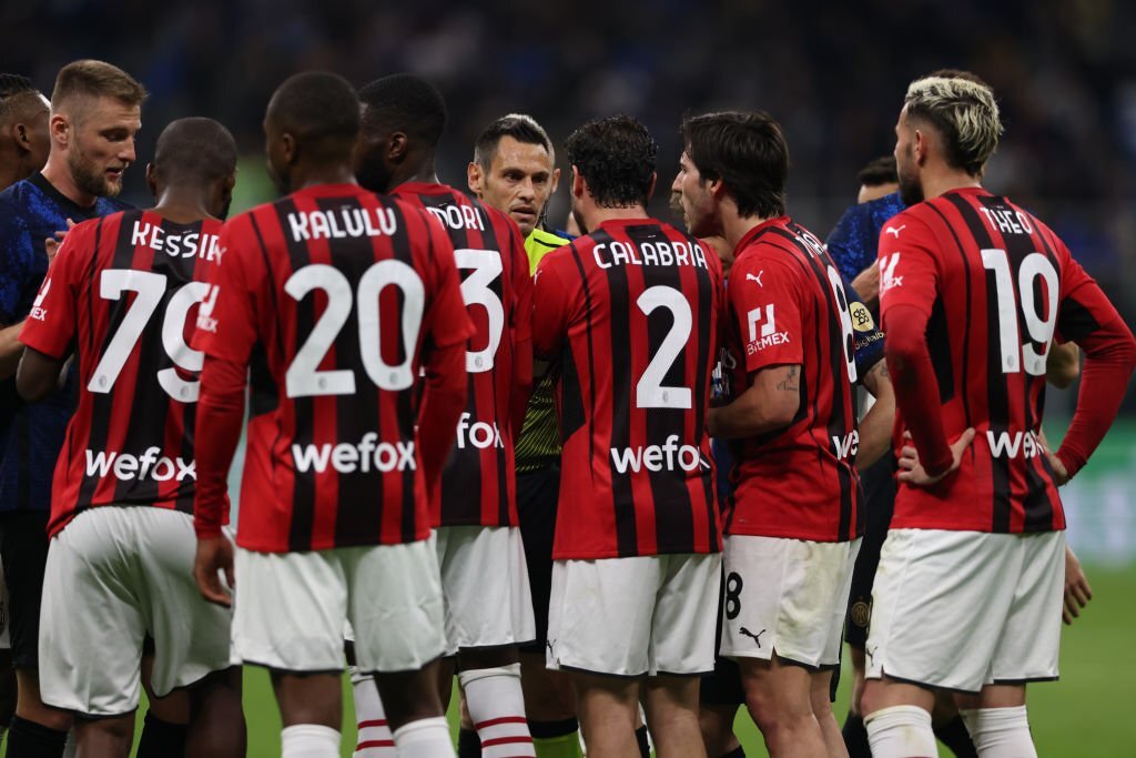 AC Milan players argue with referee mariani